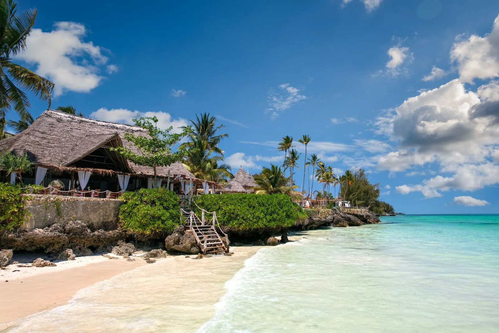Thatched beachfront hotel above a white-sand beach and turquoise sea