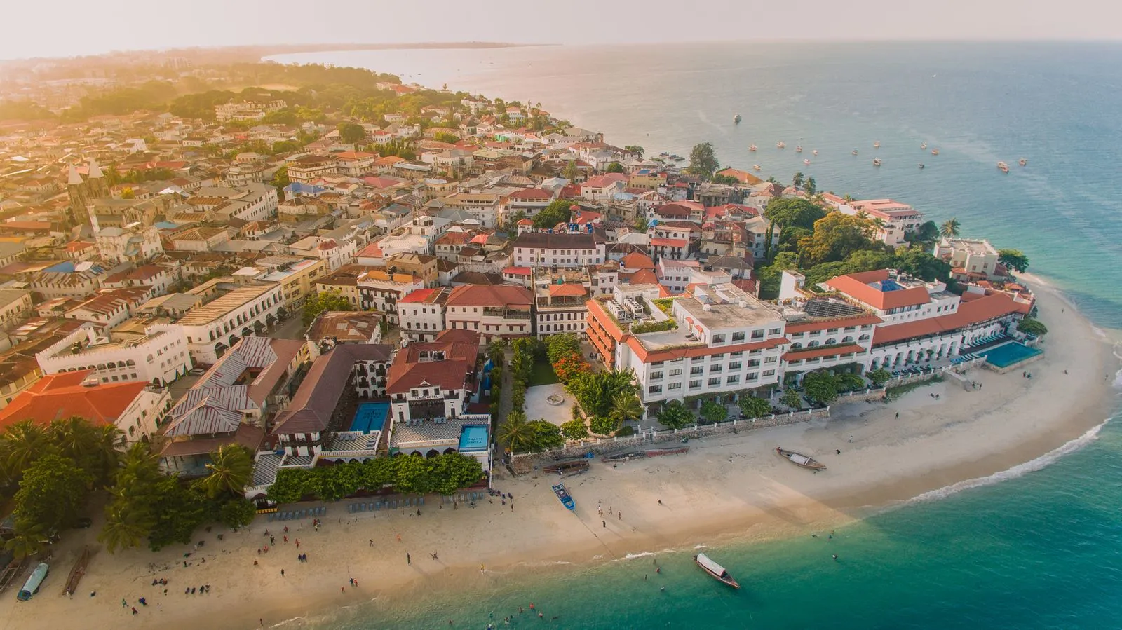 Aerial view of the Stone Town seafront hotels and beach at sunset