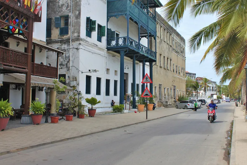 Mizingani Road in Stone Town with carved wooden balconies and palms