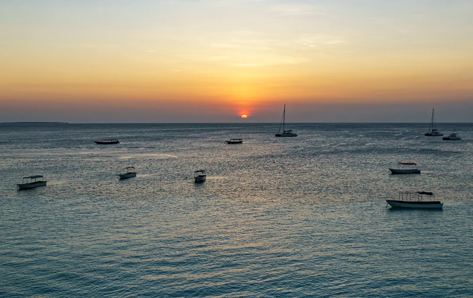 Sunset over the sea off Nungwi, with boats at anchor