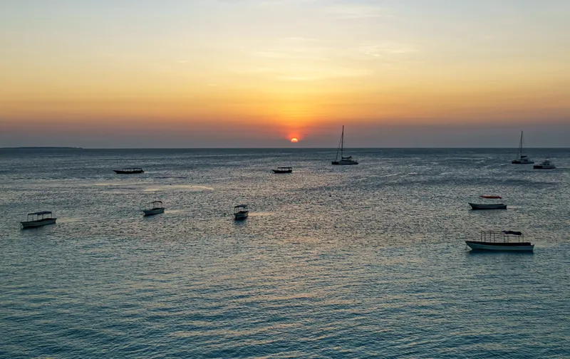 Sunset over the sea off Nungwi, with boats at anchor