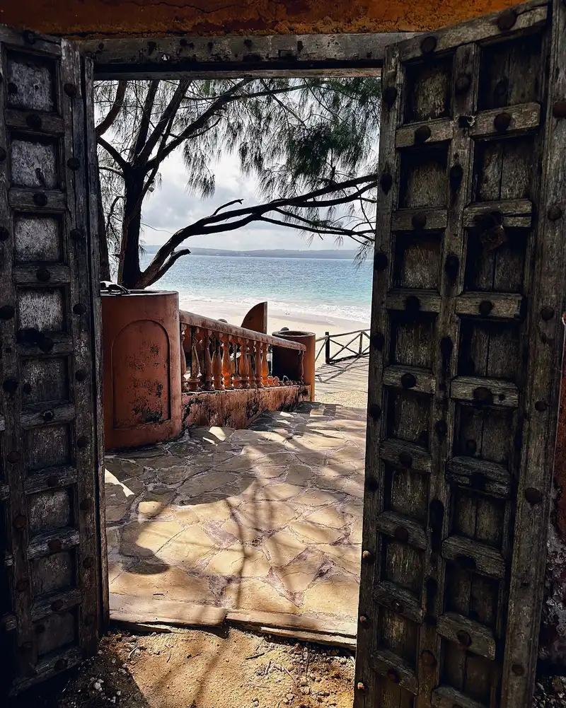 Old carved wooden gateway opening onto the beach on Changuu (Prison Island)
