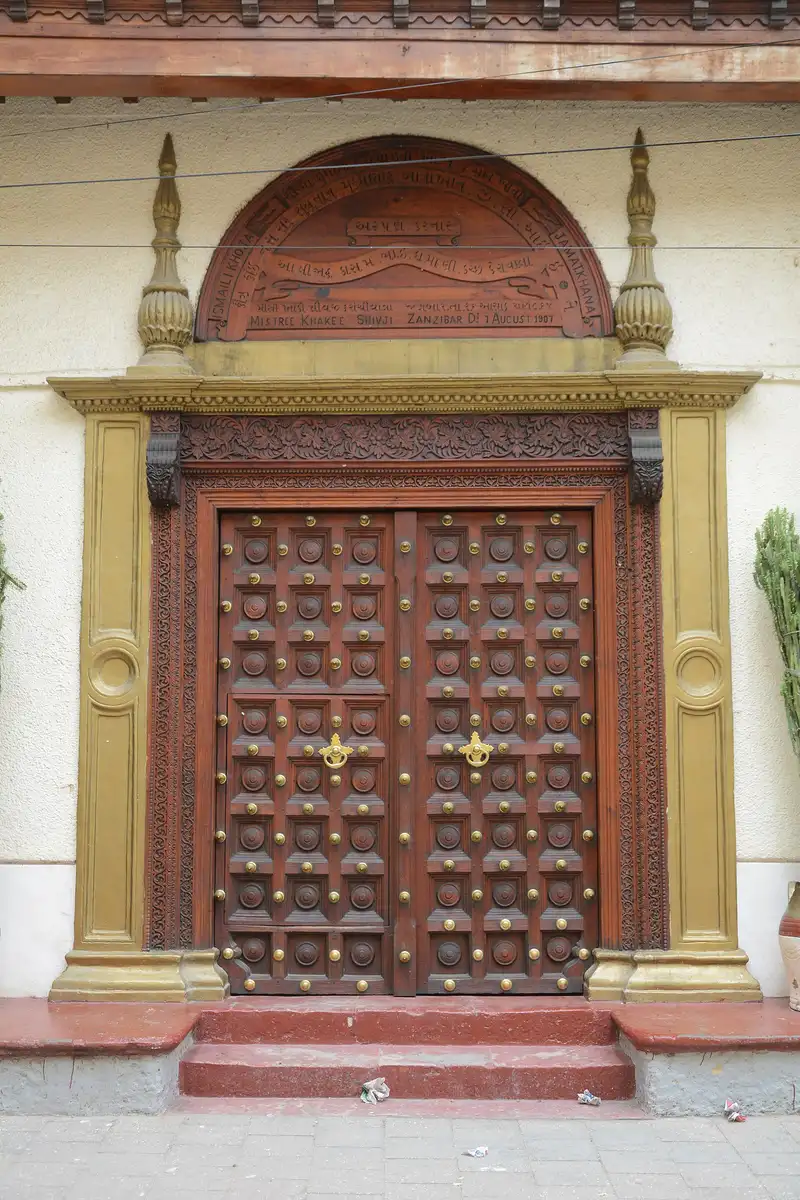 Carved Indian-style wooden door with brass studs in Stone Town
