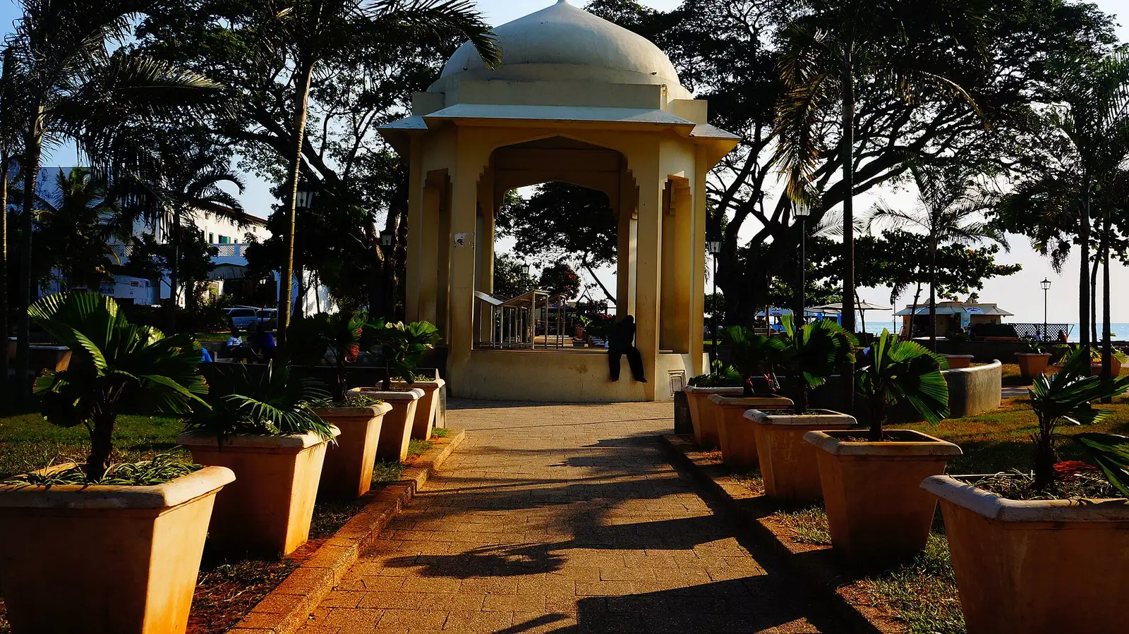 Domed pavilion and potted palms in Forodhani Gardens in late-afternoon light