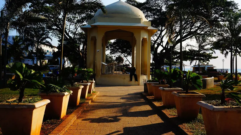 Domed pavilion and potted palms in Forodhani Gardens in late-afternoon light