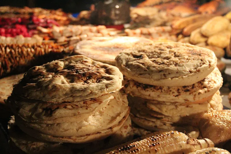 Stacks of grilled flatbread and corn on a Forodhani night market stall