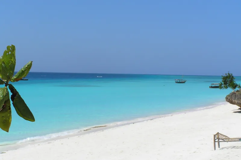 White sand and turquoise water at Nungwi, with a dhow at anchor