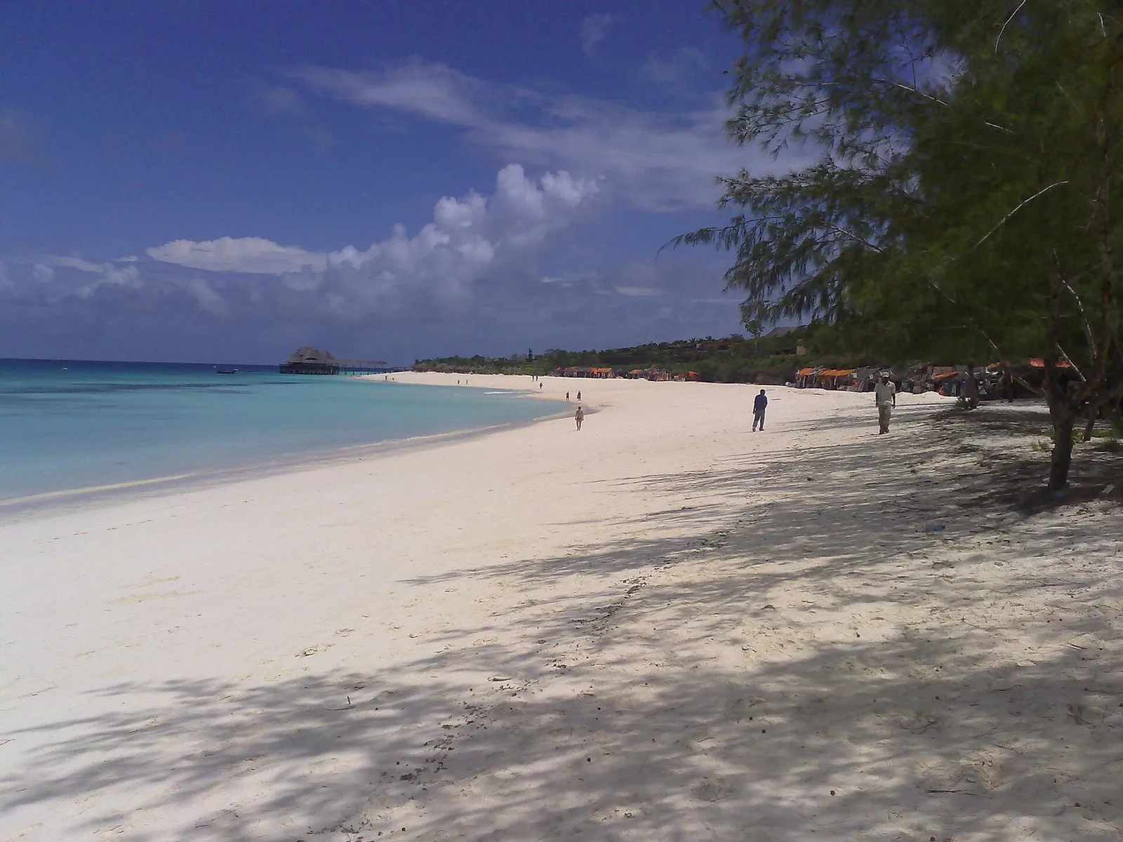 Long white sand beach with a thatched jetty restaurant, Zanzibar