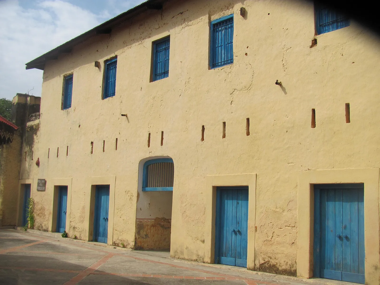 Yellow two-storey prison building with blue doors on Changuu (Prison Island)